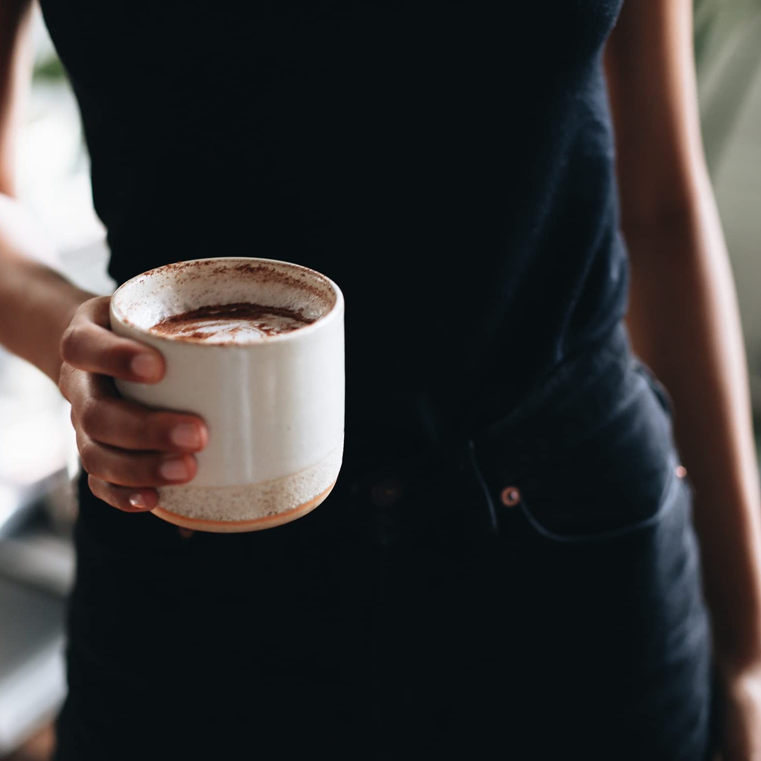 lifestyle photo of person holding a cup of coffee