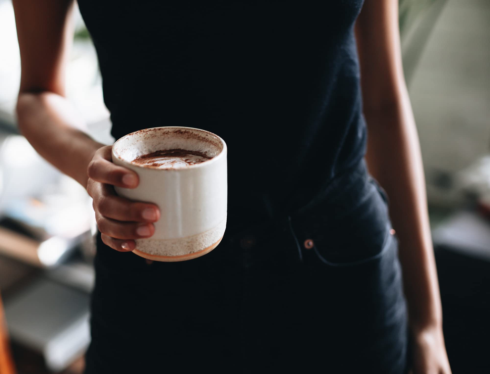 lifestyle photo of person holding a cup of coffee